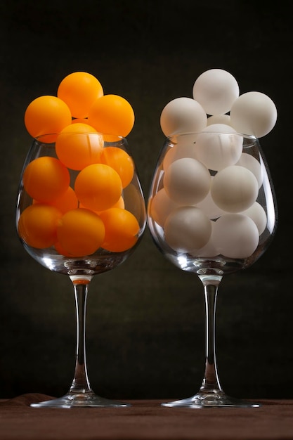 White and orange balls in two large glasses