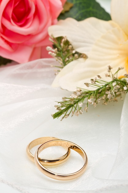 white orchids and pink rose and wedding rings