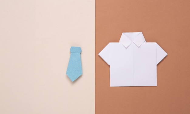 White origami paper shirt and bow tie on brown beige background