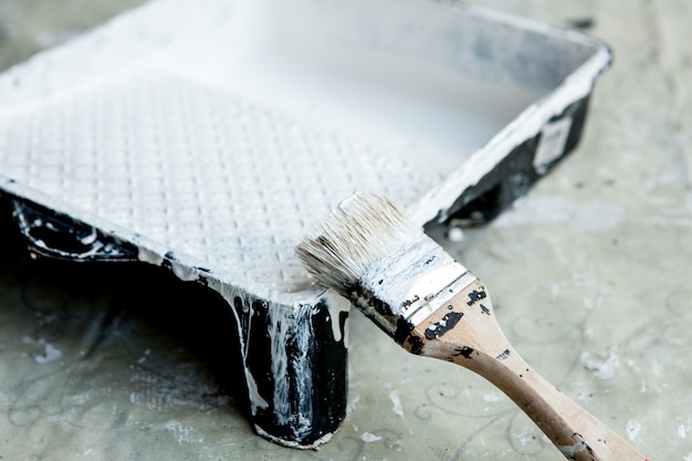 White paint, brush and tray, for painting white ceiling or trim.