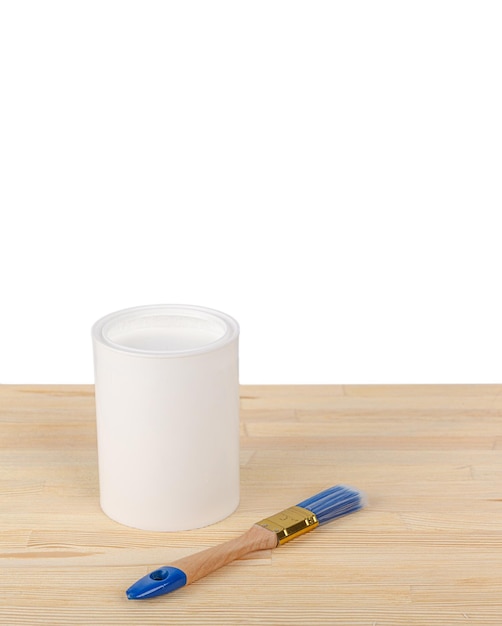 White paint with a brush on a wooden background with texture