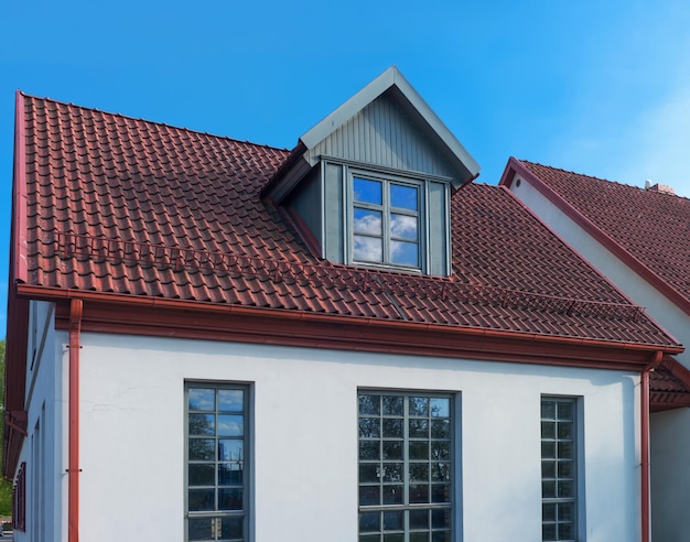 White painted house with red roof in Ventspils in Latvia. It is a city in the Courland region of Latvia. Latvia is one of the Baltic countries