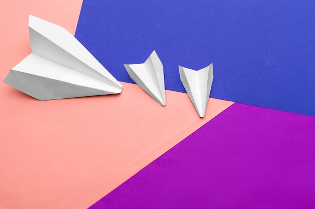 white paper airplane on a color block paper 