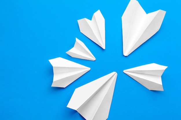 White paper airplane on a navy paper 