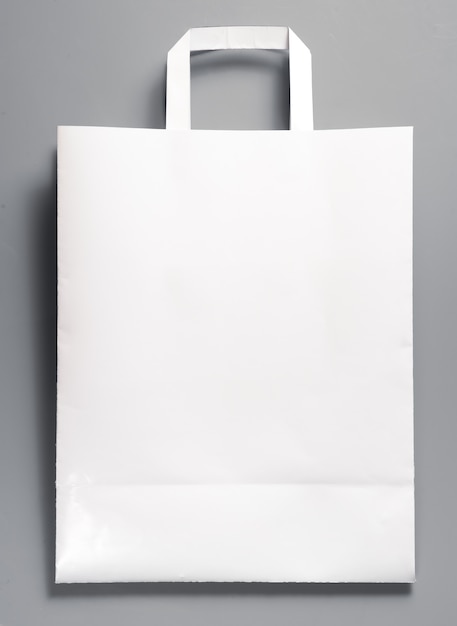 White paper bag with handles on gray background