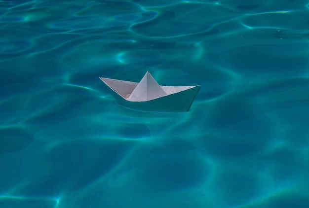 White paper boat into the clear sea water