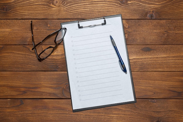 White paper clipboard on wood background