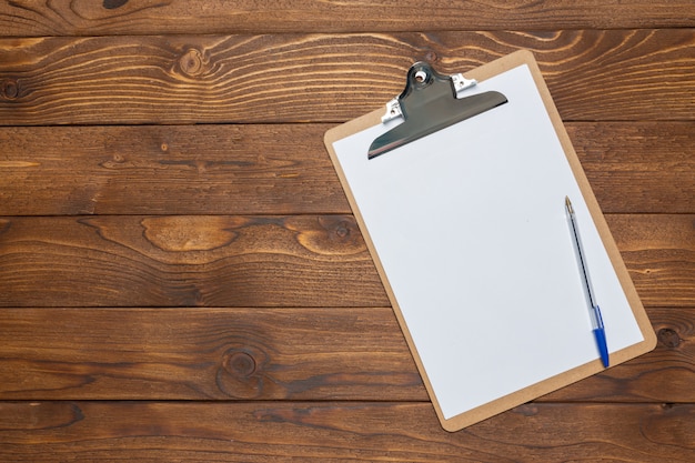 White paper clipboard on wood surface