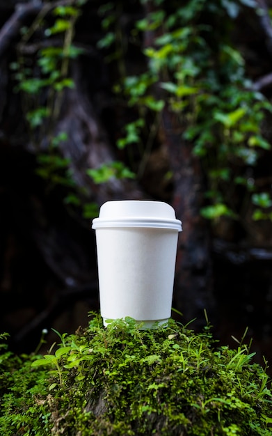 white paper cup of coffee in the beautiful nature