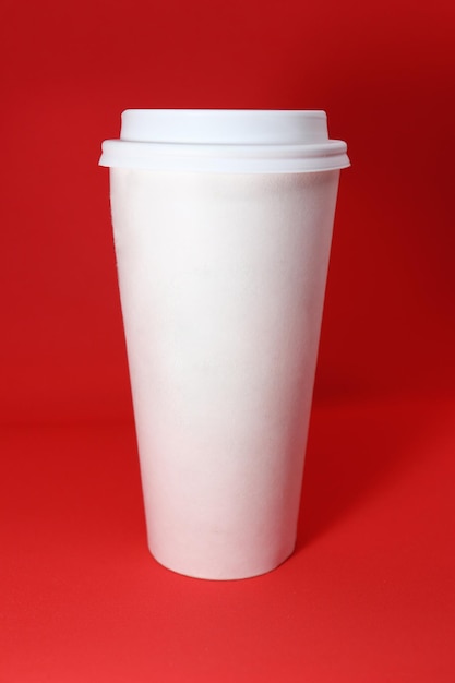 White paper cup for coffee on red background