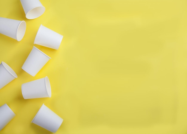 white paper disposable cups on a yellow background view from aboveflat lay copy spaes