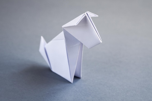 White paper dog origami isolated on a grey background