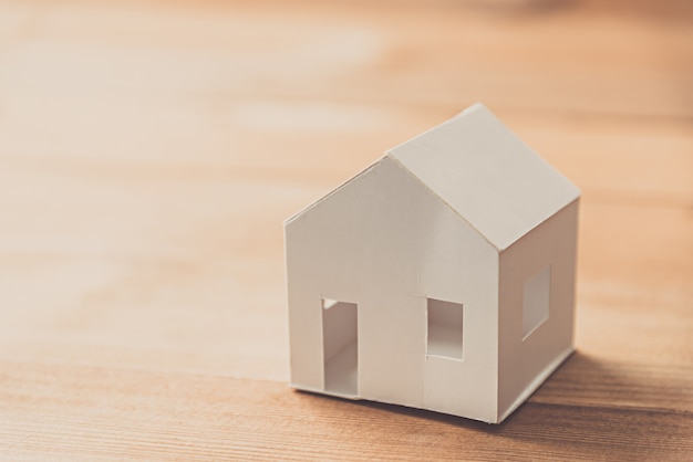 white paper house model on wooden table