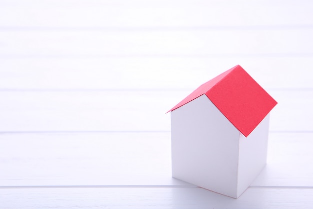 White paper house with red roof on white background