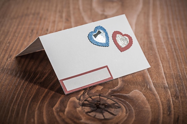 White paper invitation card on wood