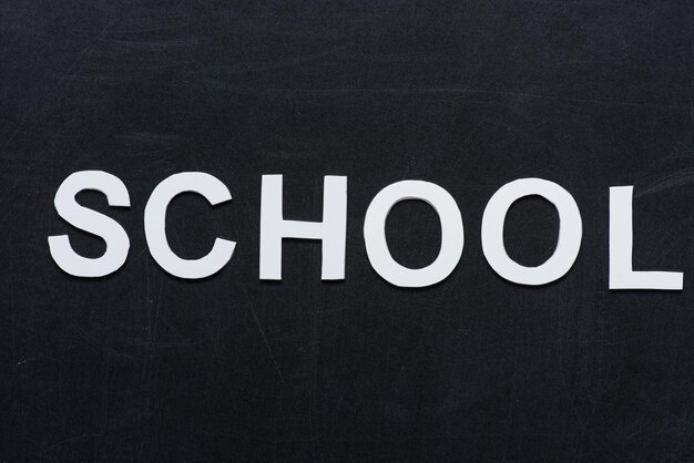 Фото Школа с белыми бумажными буквами с пространством для копирования на черной доске