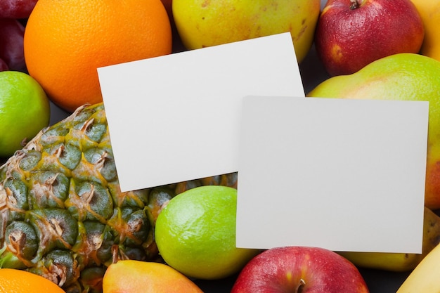 Foto mockup di carta bianca arricchito da frutta fresca che crea una festa visiva dal design sano e vivace