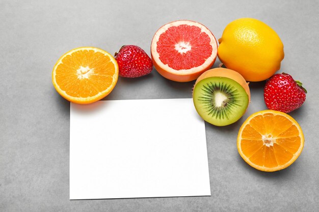 Foto mockup di carta bianca arricchito da frutta fresca che crea una festa visiva dal design sano e vivace