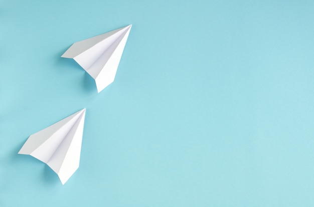 White paper planes on blue surface.