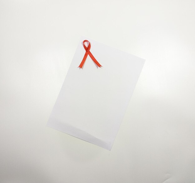 White paper reminder note add red ribbon and pen blaster