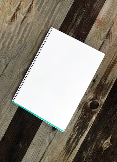 White paper sheet in a pad on the wooden table outdoors