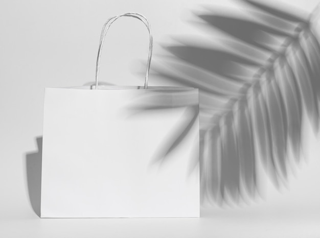 White paper shopping bag packet with handles leaf shadow