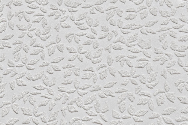 White paper wallpaper texture with abstract floral repeating pattern close up