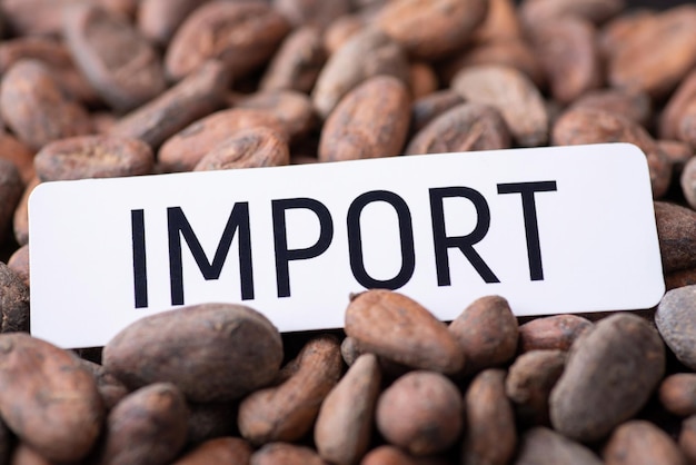 White paper with inscription Import on cocoa beans