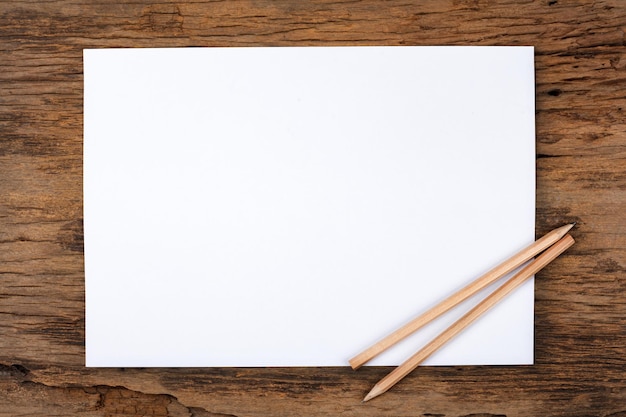 Фото Белая бумага с карандашом на деревянном столе