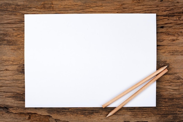 White paper with pencil on wooden table