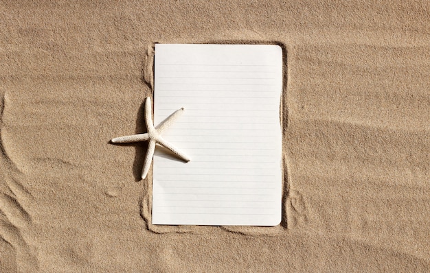 White paper with starfish on sand.