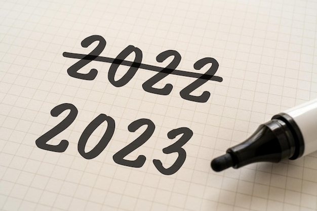 White paper written 2022 and 2023 with a marker.