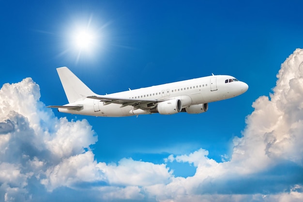 White passenger aircraft is climbing in the air above scenic clouds