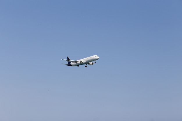 Белый пассажирский самолет, летящий в небе