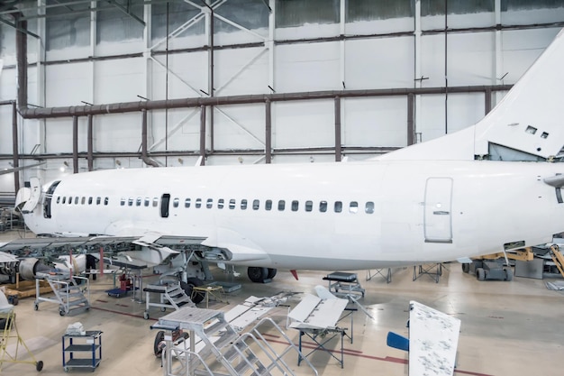 White passenger airliner in the hangar. Checking mechanical systems for flight operations