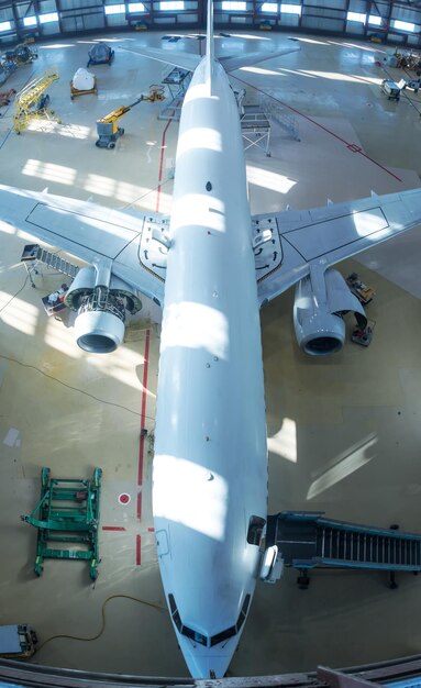 White passenger jet plane in the hangar Checking mechanical systems for flight operations