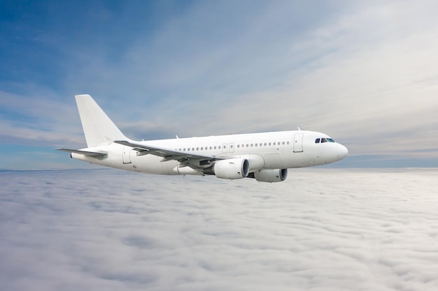 White passenger jetliner fly in the air above the clouds