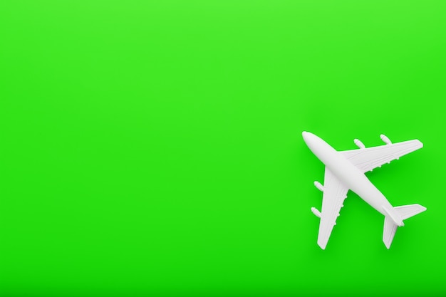 White passenger model airplane on a bright green background