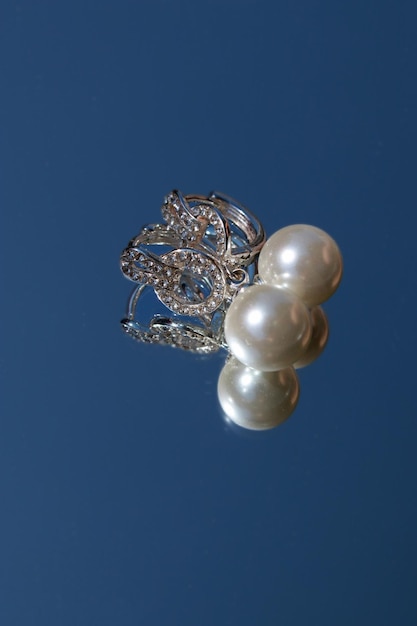 white pearl earrings on blue background