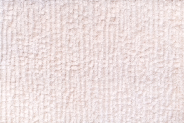 Белый жемчужный пушистый фон из мягкой, ворсистой ткани. Текстура текстильной крупным планом.