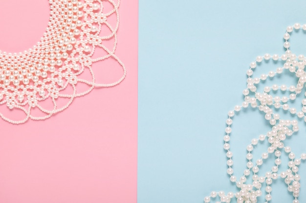 Photo white pearl necklace on pastel blue and pink paper