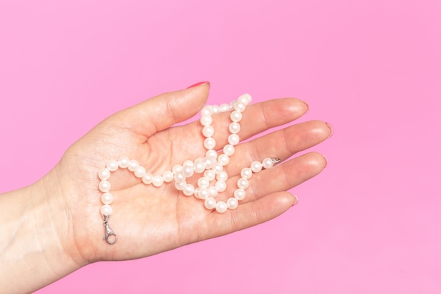 White pearl necklace on the woman's hand