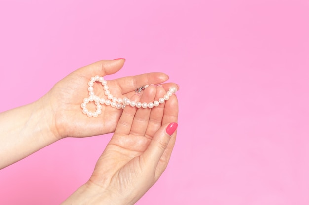 White pearl necklace on the woman's hand