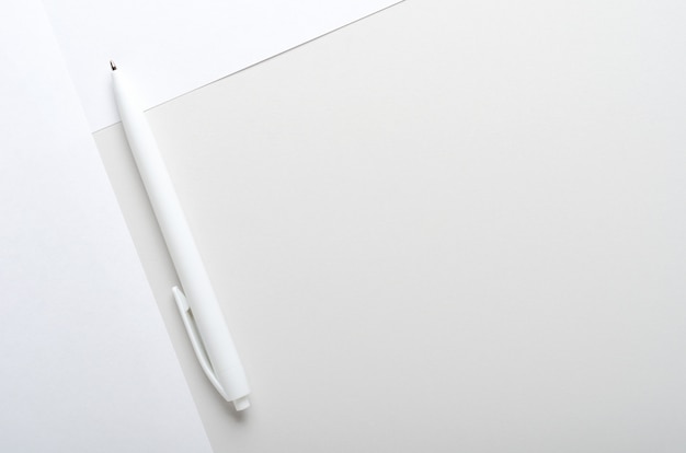 Фото Белая ручка на серой и белой бумаге на офисном столе