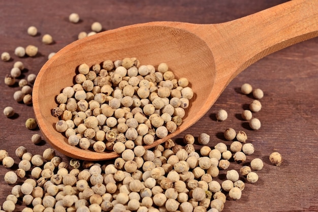 White pepper seeds in a wooden spoon