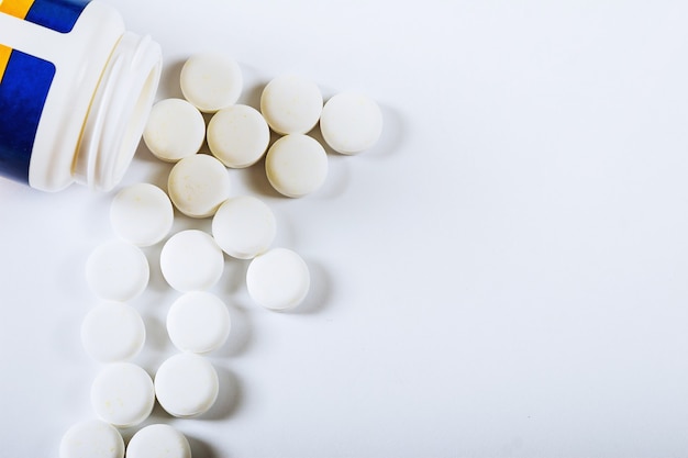 White pharmacy pills on a white background.