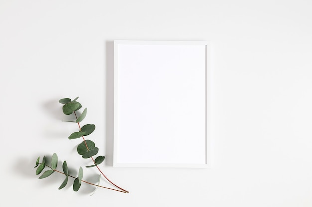 Photo white photo frame and eucalyptus leaves