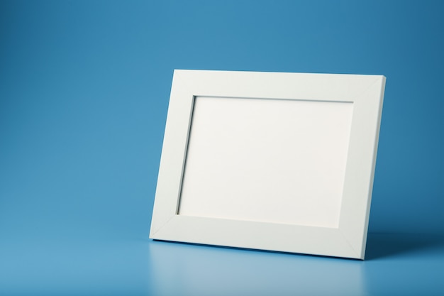 A white photo frame with an empty space on a blue background.