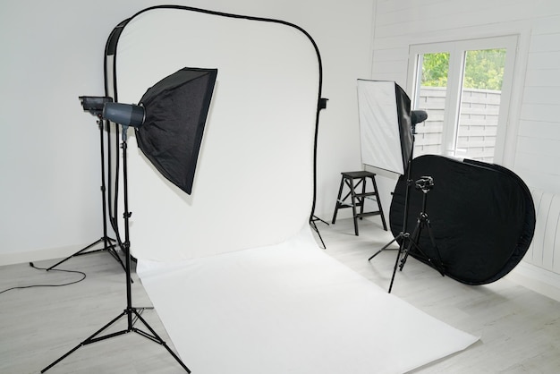 Foto interno luminoso della stanza dello studio fotografico bianco per le riprese di modelli con attrezzatura professionale