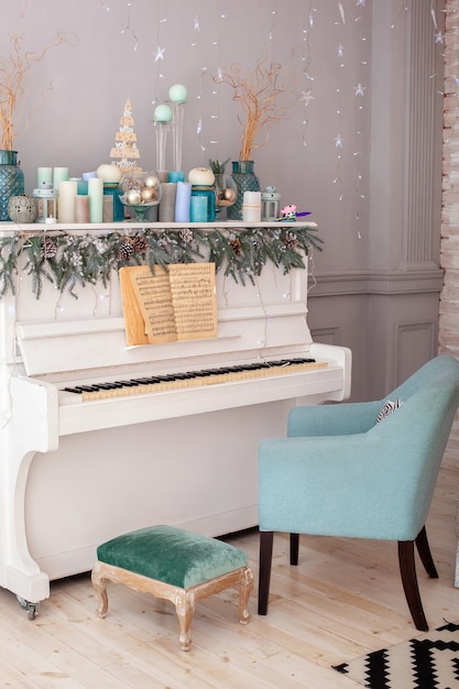 белое пианино, украшенное на рождество